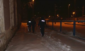 Policjanci idący nocą w rejonie torowiska