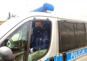 policjant siedzący w radiowozie na miejscu kierowcy