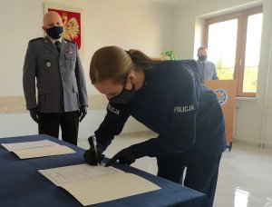policjantka podpisuje treść roty ślubowania na dalszym planie Zastępca Komendanta Powiatowego Policji w Sokółce