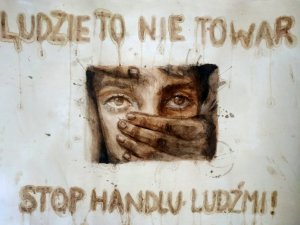 napis ludzie to nie towar stop handlu ludźmi na środku twarz kobiety dłoń zasłania jej usta